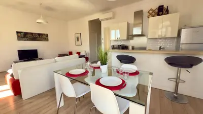 a kitchen and a living room with a table and chairs at Scène & Palmiers - Cannes in Cannes