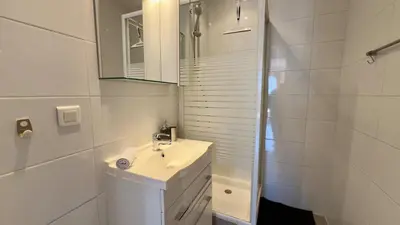 a white bathroom with a sink and a shower at Scène & Palmiers - Cannes in Cannes