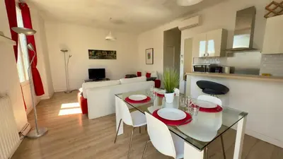a kitchen and living room with a glass table and chairs at Scène & Palmiers - Cannes in Cannes