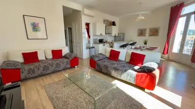 a living room with two couches and a glass table at Scène & Palmiers - Cannes in Cannes