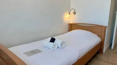 a bed with two towels on top of it at Scène & Palmiers - Cannes in Cannes