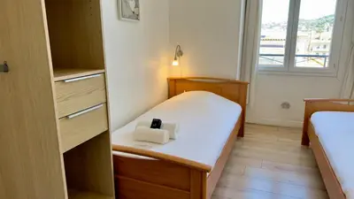 a small room with a bed with two towels on it at Scène & Palmiers - Cannes in Cannes