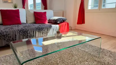 a living room with a glass coffee table in front of a couch at Scène & Palmiers - Cannes in Cannes