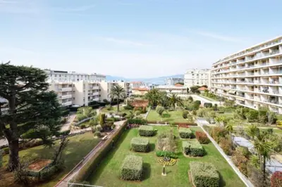 a park in front of a building with a garden at Apartment Near Beach With Sea View 2 Terraces! in Cannes