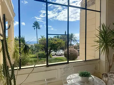a window with a view of a street and palm trees at Studio l'Atelier – Parking & Beaches 15 min Walk in Cannes