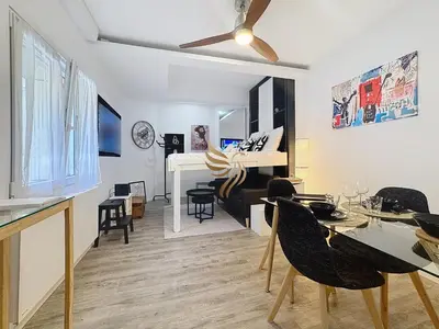 a living room with a table and a piano at Studio l'Atelier – Parking & Beaches 15 min Walk in Cannes