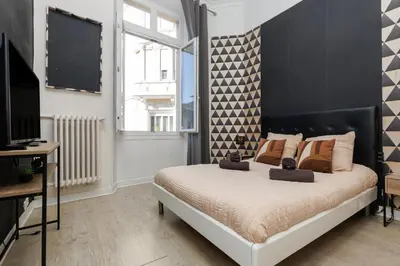 a bedroom with a bed with a black and white headboard at Le Nova - 2 chambres, Parking privé, Centre ville in Cannes
