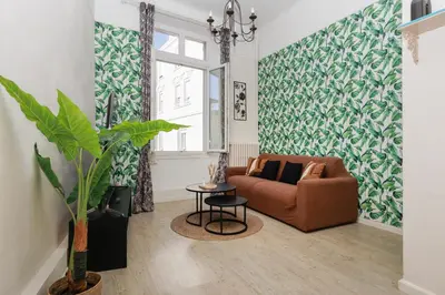 a living room with a couch and a window at Le Nova - 2 chambres, Parking privé, Centre ville in Cannes