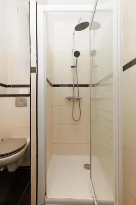 a shower with a glass door next to a toilet at Le Nova - 2 chambres, Parking privé, Centre ville in Cannes