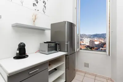 a kitchen with a stainless steel refrigerator and a window at Le Nova - 2 chambres, Parking privé, Centre ville in Cannes