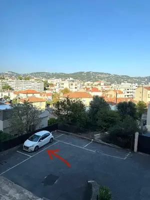 a white car parked in a parking lot with a red arrow at Le Nova - 2 chambres, Parking privé, Centre ville in Cannes