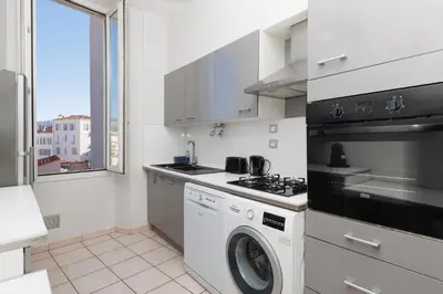 a kitchen with a stove and a washing machine at Le Nova - 2 chambres, Parking privé, Centre ville in Cannes