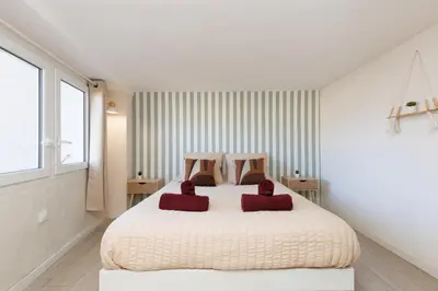 a bedroom with a bed with two red pillows on it at Le Nova - 2 chambres, Parking privé, Centre ville in Cannes