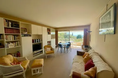 a living room with a couch and chairs and a table at Cozy flat with terrace and swimming pool in Cannes in Cannes