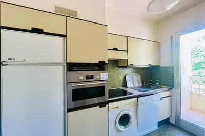 a kitchen with a refrigerator and a washer and dryer at Cozy flat with terrace and swimming pool in Cannes in Cannes