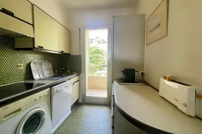 a kitchen with a sink and a washing machine at Cozy flat with terrace and swimming pool in Cannes in Cannes