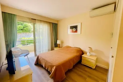 a hotel room with a bed and a window at Cozy flat with terrace and swimming pool in Cannes in Cannes