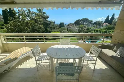 a table and chairs on a balcony with a view at Cozy flat with terrace and swimming pool in Cannes in Cannes