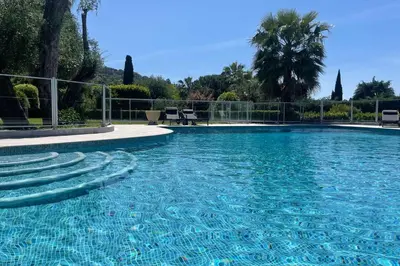 a large swimming pool with blue water at Cozy flat with terrace and swimming pool in Cannes in Cannes