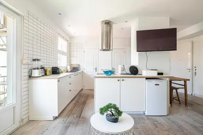 a kitchen with white cabinets and a table at Superb flat - 2BR- 4 P - Cannes in Cannes