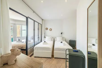 a hotel room with two beds and a mirror at Superb flat - 2BR- 4 P - Cannes in Cannes