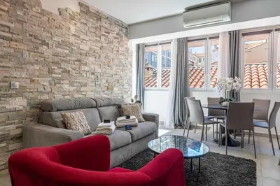 a living room with a couch and a brick wall at Charming flat - AC - 2BR - 6P - Cannes in Cannes