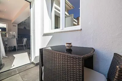 a wicker table with a vase on it on a patio at Charming flat - AC - 2BR - 6P - Cannes in Cannes