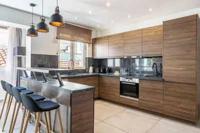 a kitchen with wooden cabinets and a bar with stools at Charming flat - AC - 2BR - 6P - Cannes in Cannes