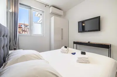 a bedroom with a bed and a flat screen tv at Charming flat - AC - 2BR - 6P - Cannes in Cannes