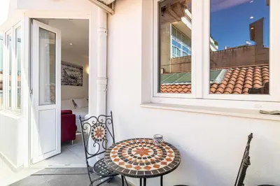 a table and chair on a porch with a window at Charming flat - AC - 2BR - 6P - Cannes in Cannes