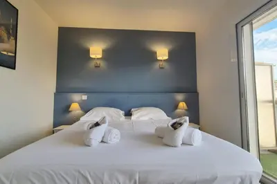 a bedroom with a white bed with three pillows at Beautiful 2-bedroom apt - sea and city view in Cannes
