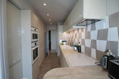 a kitchen with white cabinets and a counter top at Beautiful 2-bedroom apt - sea and city view in Cannes