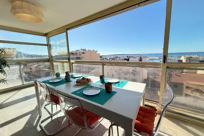 a dining room with a table and chairs on a balcony at Beautiful 2-bedroom apt - sea and city view in Cannes