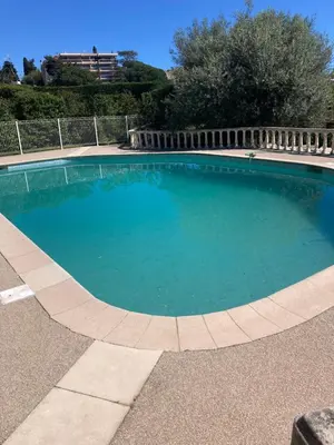 a large swimming pool with blue water at Les alizés Cannes in Cannes