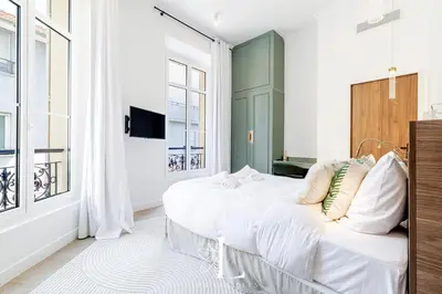 a bedroom with a large white bed and windows at Les Lucioles 4- Luxury 1 Bedroom Apartment in Cannes