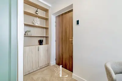 a hallway with a wooden door and a chair at Les Lucioles 4- Luxury 1 Bedroom Apartment in Cannes