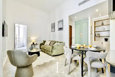 a living room with a table and chairs and a couch at Les Lucioles 4- Luxury 1 Bedroom Apartment in Cannes