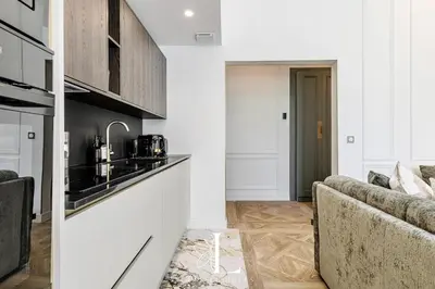 a living room with a couch and a kitchen at Les Lucioles 5- Luxury 2-Bedroom Apartment in Cannes