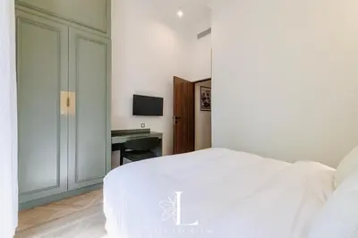 a bedroom with a white bed and a desk at Les Lucioles 5- Luxury 2-Bedroom Apartment in Cannes