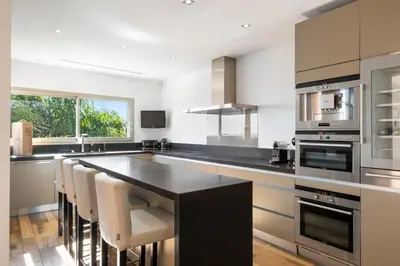 a kitchen with a black counter and white appliances at REF 2138 - Cannes - Villa sea view in Cannes
