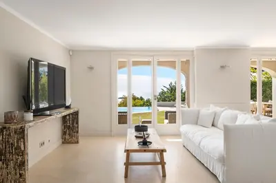 a white living room with a white couch and a tv at REF 2138 - Cannes - Villa sea view in Cannes