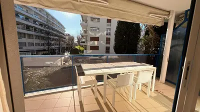 a table and chairs on a balcony with a view of a building at Avenue de Madrid 19 - Croisette Madrid in Cannes