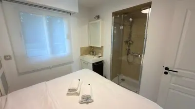 a white bathroom with a bed and a shower at Avenue de Madrid 19 - Croisette Madrid in Cannes