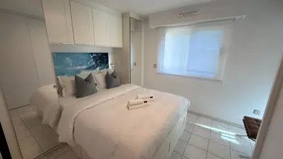 a bedroom with a large white bed with a window at Avenue de Madrid 19 - Croisette Madrid in Cannes