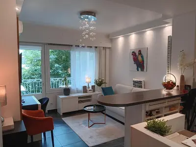 a living room with a table and a dining room at L'Atlantide in Cannes