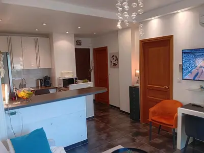 a kitchen with a counter and an orange chair at L'Atlantide in Cannes