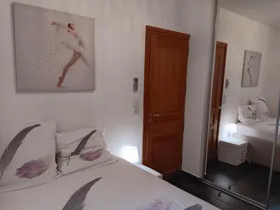 a bedroom with a white bed and a mirror at L'Atlantide in Cannes