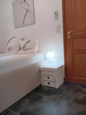a bedroom with a bed and a nightstand with a lamp at L'Atlantide in Cannes