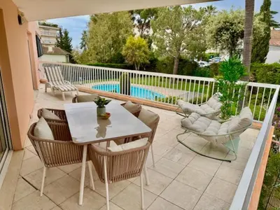 a patio with a table and chairs and a pool at The Noailles - Lovely flat with swimming pool five minutes from the beach in Cannes