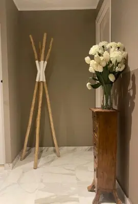 a vase of flowers sitting on a table next to wooden sticks at The Noailles - Lovely flat with swimming pool five minutes from the beach in Cannes